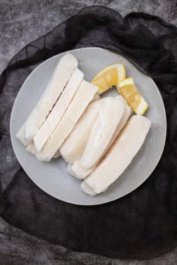 Tabağında limon olan taze donmuş mürekkep balığı.