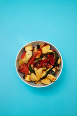 Beyaz tabakta fırında sebze. Fırında domates, kabak ve kırmızı biber. Sağlıklı vejetaryen gıda kavramı.