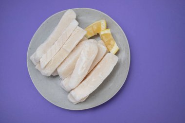 Tabağında limon olan taze donmuş mürekkep balığı.