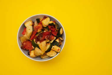 Beyaz tabakta fırında sebze. Fırında domates, kabak ve kırmızı biber. Sağlıklı vejetaryen gıda kavramı.