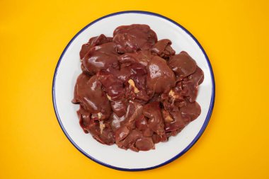 Beyaz tabakta çiğ tavuk ciğeri eti.