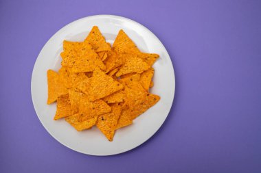 Beyaz tabakta portakallı Meksika cipsi.