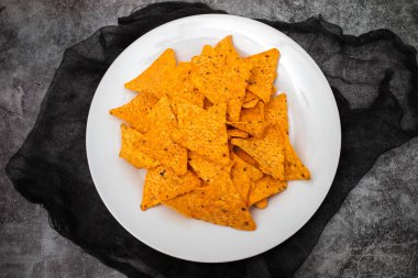 Beyaz tabakta portakallı Meksika cipsi.