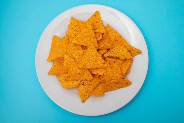 Beyaz tabakta portakallı Meksika cipsi.