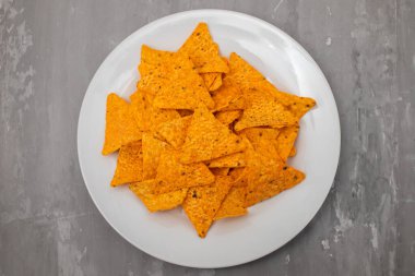 Beyaz tabakta portakallı Meksika cipsi.