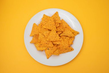 Beyaz tabakta portakallı Meksika cipsi.