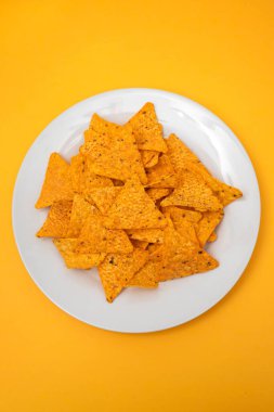 Beyaz tabakta portakallı Meksika cipsi.