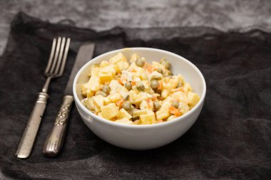 Küçük beyaz kasede Rus sebze salatası