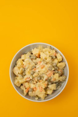 Küçük beyaz kasede Rus sebze salatası