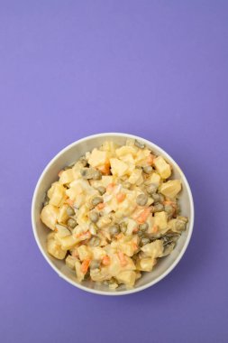 Küçük beyaz kasede Rus sebze salatası