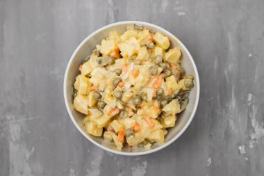 Küçük beyaz kasede Rus sebze salatası