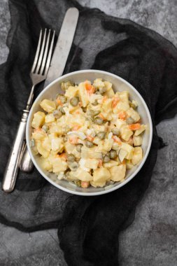 Küçük beyaz kasede Rus sebze salatası