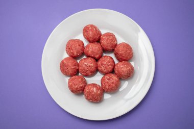 Beyaz tabakta çiğ et toplarının üst görünümü