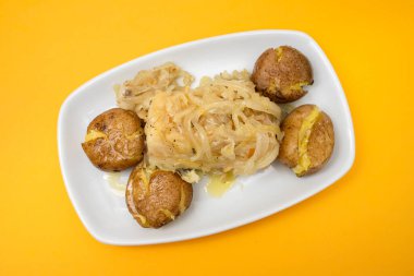 Lezzetli fırında patates, tuz ve yağ parçaları beyaz tabakta.