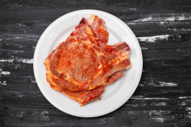 Büyük beyaz tabakta dilimlenmiş, soslu ve biberli domuz eti.