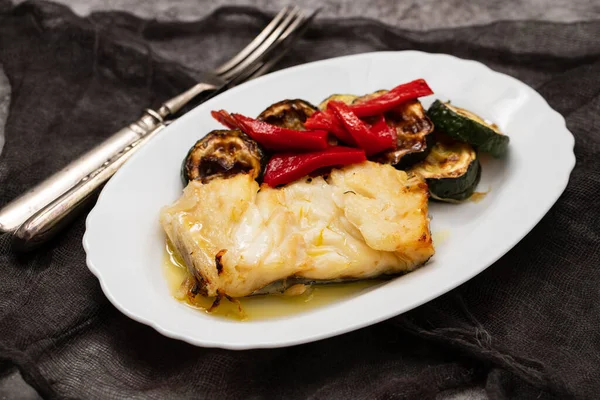 魚料理 ホワイトプレートで焼いた野菜と揚げコード魚 ロイヤリティフリーのストック写真
