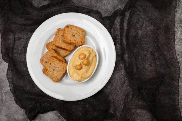 Uma Tigela Hummus Mergulho Com Mini Torradas Placa Branca Imagem De Stock