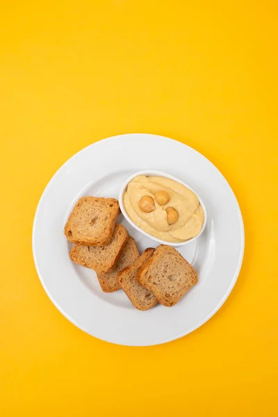 Een Kom Hummus Dip Met Mini Toastjes Witte Plaat Stockfoto