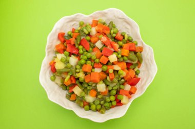 Beyaz kasede taze sebzelerin karışımı, üst manzara.