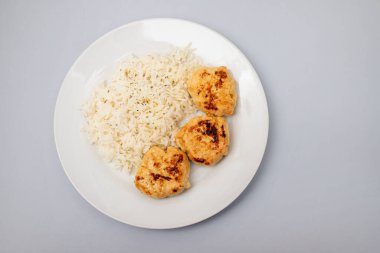 Kızarmış tavuk köftesi ve kaynamış pirinç.