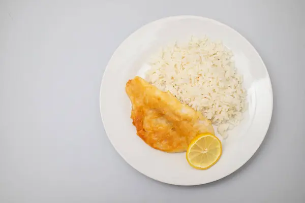 stock image Fried fish fillets with rice and lemon on white plate