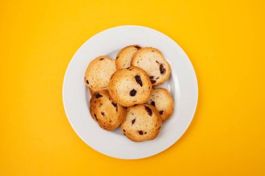 Kuru üzümlü taze pişmiş ruslar, küçük beyaz tabakta.