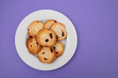 Kuru üzümlü taze pişmiş ruslar, küçük beyaz tabakta.
