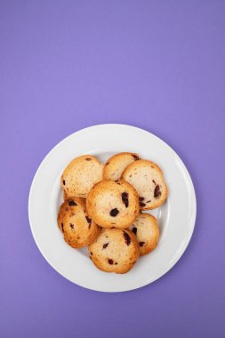 Kuru üzümlü taze pişmiş ruslar, küçük beyaz tabakta.