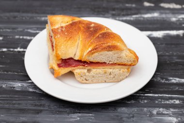 Roket, hindi jambonu, krem peynir ve domates dolu simit.