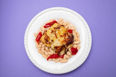 Beyaz fasulyeli kızarmış morina balığı ve beyaz tabakta ızgara kırmızı biber.