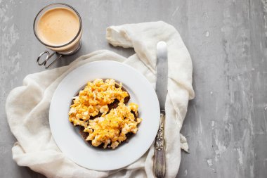 Beyaz tabakta siyah ekmekle çırpılmış yumurta.