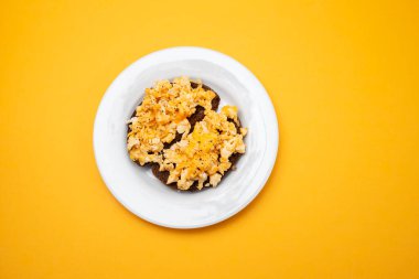 Beyaz tabakta siyah ekmekle çırpılmış yumurta.