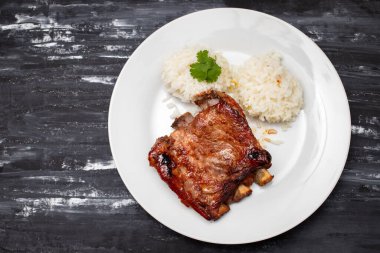 Beyaz tabakta haşlanmış pirzola ve pilav.