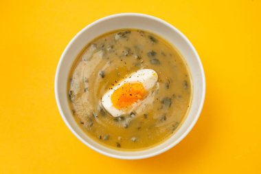 Yeşil çorba. Beyaz kasede kaynamış yumurta ile ıspanak kremalı çorba..