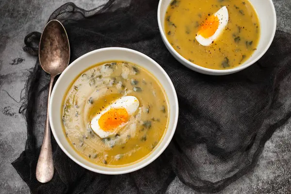 Yeşil çorba. Beyaz kasede kaynamış yumurta ile ıspanak kremalı çorba..