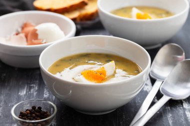 Yeşil çorba. Beyaz kasede kaynamış yumurta ile ıspanak kremalı çorba..