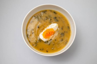 Yeşil çorba. Beyaz kasede kaynamış yumurta ile ıspanak kremalı çorba..