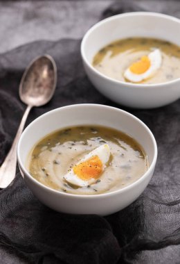 Yeşil çorba. Beyaz kasede kaynamış yumurta ile ıspanak kremalı çorba..