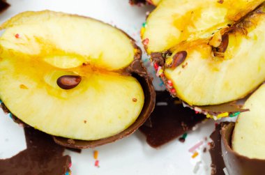 Elma şekeri parçacıkları. Sütlü çikolatayla kaplanmış. Renkli şeker parçacıkları, şekerleme.