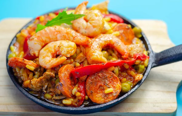 Lezzetli paella, pilav pilavı, tavuk budu, karides, domates ve sucuk, geleneksel İspanyol yemeği.