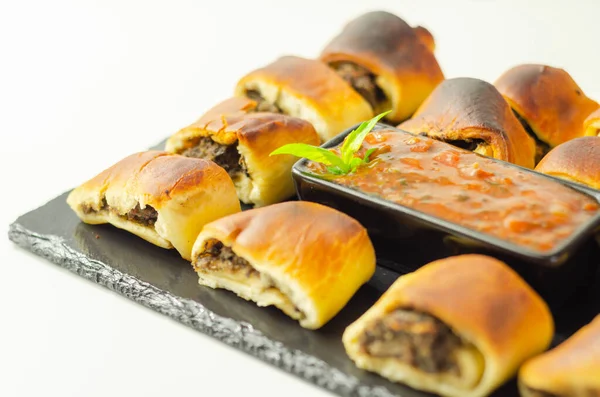 Patty\'s pies stuffed with minced meat, mushrooms and onion, served with sauce, party appetizer