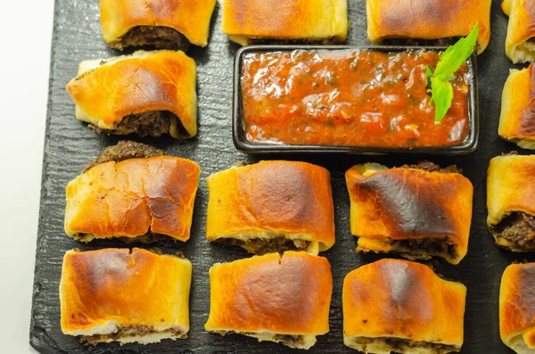 Patty's pies stuffed with minced meat, mushrooms and onion, served with sauce, party appetizer