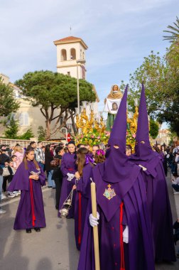 ALMERIA, İSPAN - Nisan 06, 2023 Kutsal Hafta 'da insanların geçit töreni. Törene katılan sakinler üzerinde azizlerin resimleri olan platformlar giyerler.