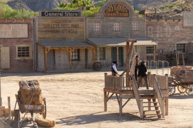 ALMERIA, SPAIN - 17 Aralık 2022 Ayrı Vahşi Batı kostümleri içinde, Batılı bir kasabadaki aktörler bir banka soygunu gösterisi düzenlediler.