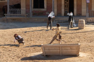 ALMERIA, SPAIN - 17 Aralık 2022 Ayrı Vahşi Batı kostümleri içinde, Batılı bir kasabadaki aktörler bir banka soygunu gösterisi düzenlediler.