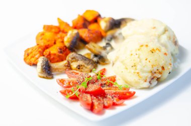 Kızarmış tavuk göğsü ve yanında patates püresi, mantar ve taze vişneli domates ve sağlıklı besinle servis edilen tatlı biberli salamura.