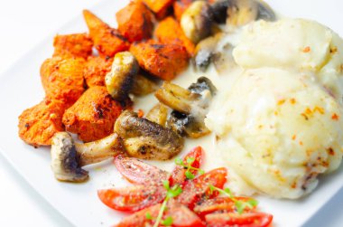 Kızarmış tavuk göğsü ve yanında patates püresi, mantar ve taze vişneli domates ve sağlıklı besinle servis edilen tatlı biberli salamura.