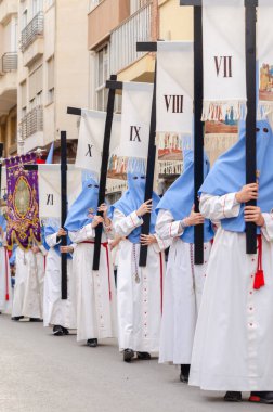 ALMERIA, İSPAN - Nisan 04, 2023 Kutsal Hafta 'da insanların geçit töreni. Törene katılan sakinler üzerinde azizlerin resimleri olan platformlar giyerler.