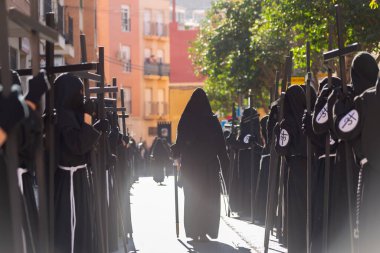 ALMERIA, İSPAN - Nisan 05, 2023 Kutsal Hafta 'da insanların geçit töreni. Törene katılan sakinler üzerinde azizlerin resimleri olan platformlar giyerler.