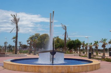 ALMERIA, İspanya - 24 Mayıs 2023 Gezinti güvertesinde büyük bir tekne çeşmesi, tekne gövdesi ve yelkeni farklı renklerde akan su perdeleridir.